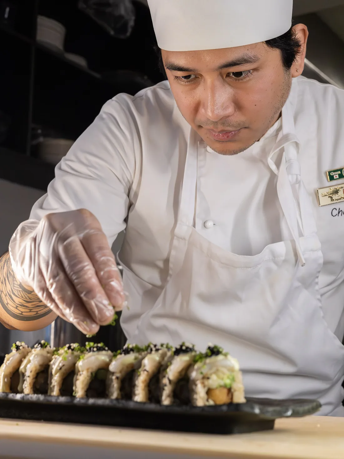 Kokk hos Sushi Roll gjør klar en rull